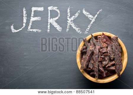 beef jerky in bowl on chalkboard
