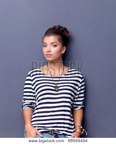 A young woman standing, isolated on graybackground