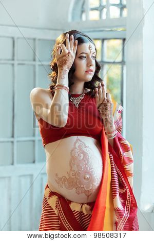 The pregnant woman belly with henna tattoo