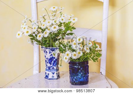 Feverfew in vases with an vintagae look.