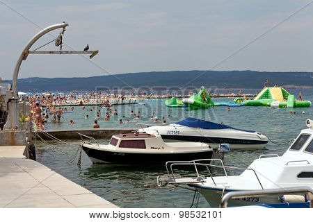 SELCE, CROATIA - JULY 24, 2015: People swimming and sunbathing on the Selce beach