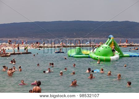 SELCE, CROATIA - JULY 24, 2015: People swimming and sunbathing on the Selce beach