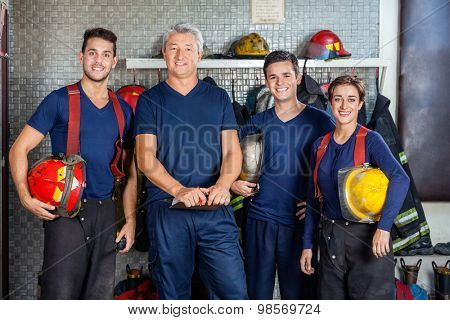 Portrait of confident firefighters standing together at fire station