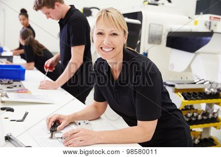 Workers In Engineering Factory Checking Component Quality