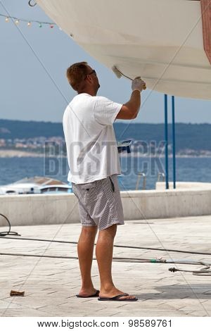 Man painting a boat