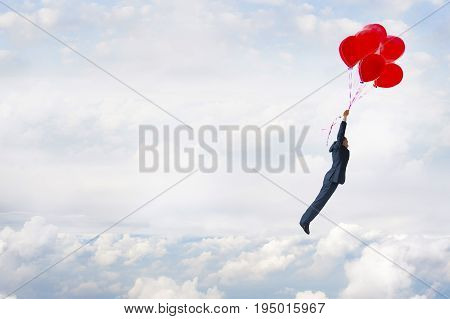 business freedom concept businessman flying in the sky with balloons
