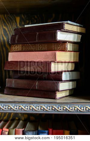Read Paper old book stacked on wooden shelf in the interior of the library. Education and intelligence are well-read people. Old gadgets from short stories and novels. The passing of time read.