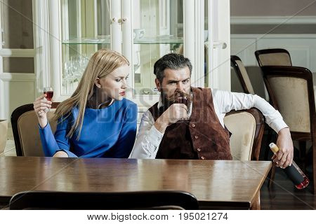 Girl And Man Sharing Bottle Of Wine In Restaurant