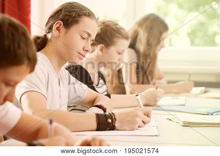 Students or pupils writing test in school being concentrated