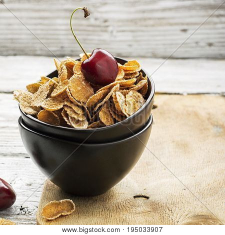Healthy breakfast concept: whole-grain cereals with berries in ceramic bowls on a wooden light background. Selective focus
