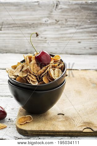 Healthy breakfast concept: whole-grain cereals with berries in ceramic bowls on a wooden light background. Selective focus