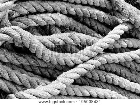 A well used and worn rope lays in a pile ready for its next use.