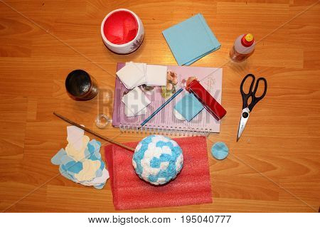 The process of making topiary (paper flower) - all necessary materials and tools are laid out on the floor.