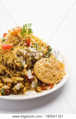 Bhel Puri - Popular Mumbai street food served with coriander and tamarind chutney on white background, selective focus