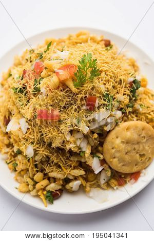Bhel Puri - Popular Mumbai street food served with coriander and tamarind chutney on white background, selective focus