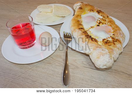 Adjarian khachapuri close-up. This traditional georgian dish contains brinsen cheese butter and row egg. Delicious homemade khachapuri in Adjarian