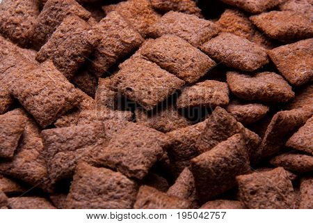 Chocolate breakfast cereal texture. Cereal balls as background. Chocolate corn balls wallpaper background cover.