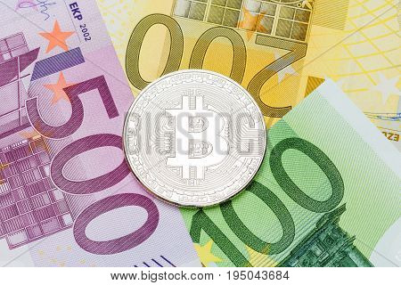 Silver Bitcoin close-up. Euro currency as a background. Macro photo.  High resolution photo.