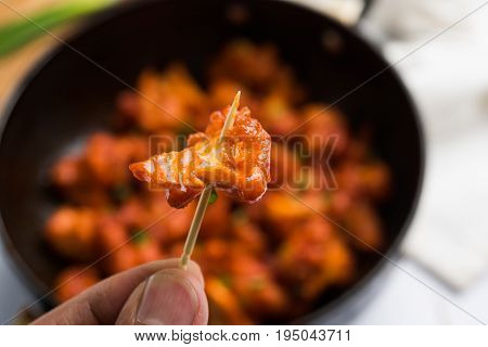 Gobi Manchurian dry - Popular street food of India made of cauliflower florets in a frying pan, selective focus