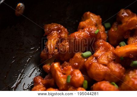 Gobi Manchurian dry - Popular street food of India made of cauliflower florets in a frying pan, selective focus