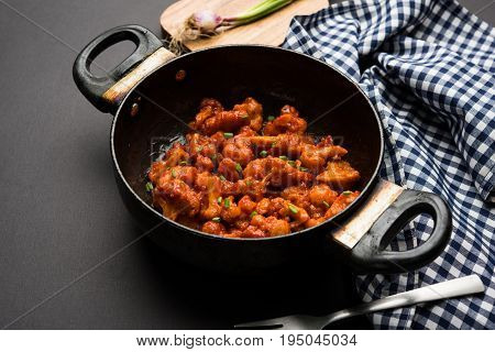 Gobi Manchurian dry - Popular street food of India made of cauliflower florets in a frying pan, selective focus