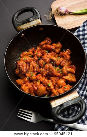 Gobi Manchurian dry - Popular street food of India made of cauliflower florets in a frying pan, selective focus