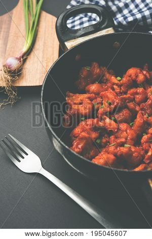 Gobi Manchurian dry - Popular street food of India made of cauliflower florets in a frying pan, selective focus