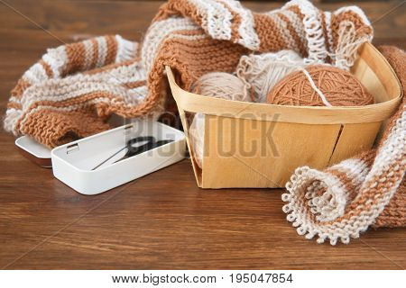 Balls of wool and knitting on the wooden background