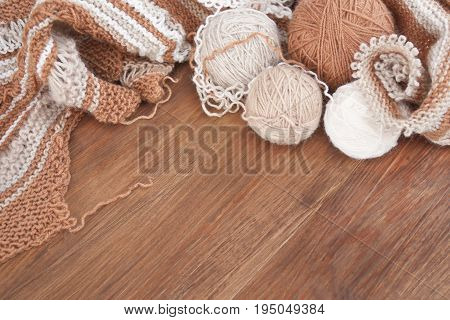 Balls of wool and knitting on the wooden background