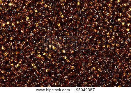 Close up of multicolored golden seed beads. High resolution photo.