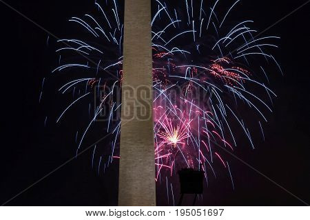 Red white and boue fireworks explode behind the Washington Monument on July 4 2017 on the mall in washington DC