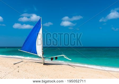 BORACAY WESTERN VISAYAS PHILIPPINES - JANUARY 14 2015: Single traditional boat with two lifeguards in the perfect Puka Beach Boracay.