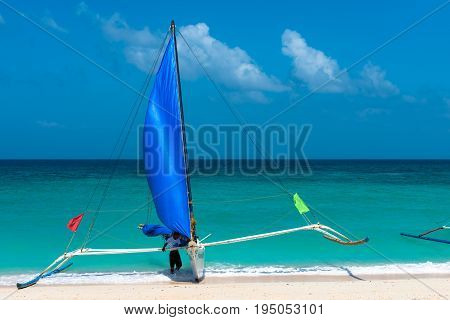 BORACAY WESTERN VISAYAS PHILIPPINES - JANUARY 14 2015: Horizontal picture of a traditional boat with a native filipino at Puka Beach.