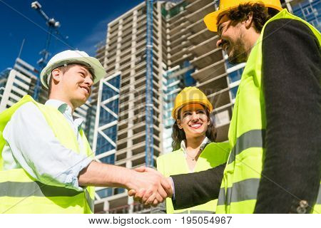 Architects and foreman in meeting at construction site of high-riser