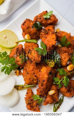 Chicken 65 - spicy deep fried Bar appetizer or quick snack from India in a bowl or plate over white background, selective focus