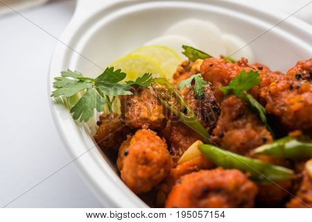 Chicken 65 - spicy deep fried Bar appetizer or quick snack from India in a bowl or plate over white background, selective focus
