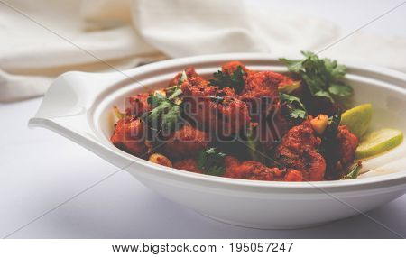 Chicken 65 - spicy deep fried Bar appetizer or quick snack from India in a bowl or plate over white background, selective focus