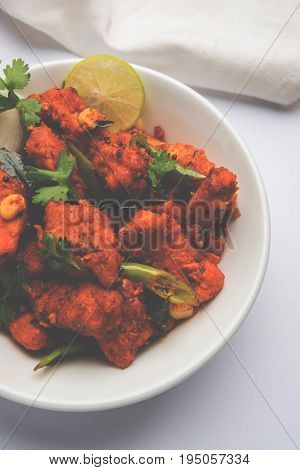 Chicken 65 - spicy deep fried Bar appetizer or quick snack from India in a bowl or plate over white background, selective focus
