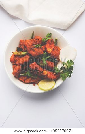 Chicken 65 - spicy deep fried Bar appetizer or quick snack from India in a bowl or plate over white background, selective focus