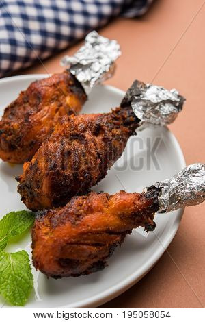 Chicken Tangri kabab or kebab - three Chicken leg pieces marinated with red sauce then grilled and served with salad. It can be served with green chutney