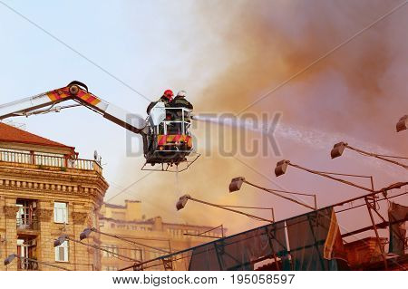 Fire fighters on a platform extinguish fire at Kreschatyk street in Kiev Ukraine