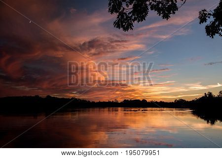 A firey orange sunset over the water with a nice reflection