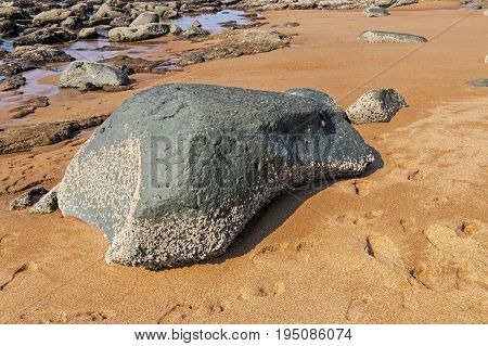 Close up of sand and rocks and footprints on coastal shoreline in South Africa