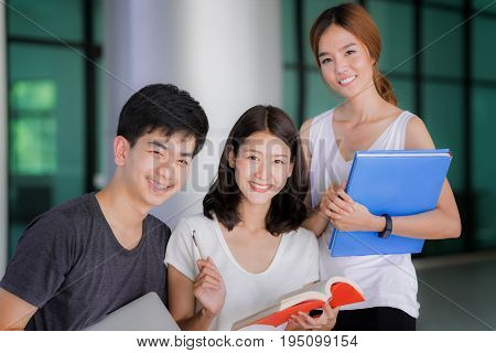 Asian student do report and home work togather at library in university