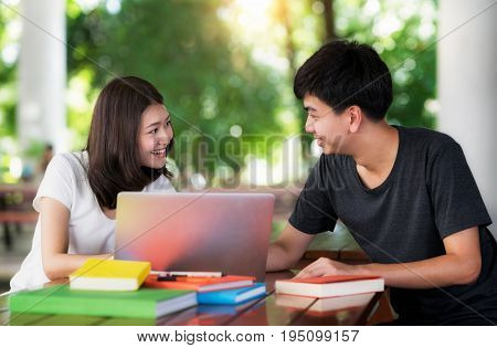 Asian student do report and home work togather at library in university