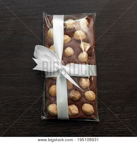 Tile Of  Homemade Milk Chocolate With Hazelnut On Dark Wooden Background. Squqre Image