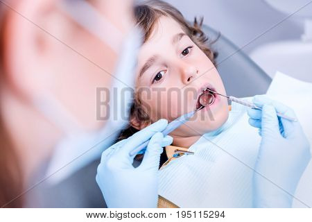 Close Up View Of Dentist Examining Teeth Of Little Boy In Dentist Office