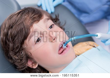 Close Up View Of Dentist Treating Teeth Of Little Boy In Dentist Office