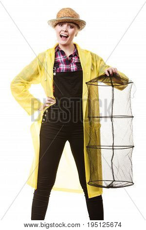 Spinning angling cheerful fisherwoman concept. Happy woman in yellow raincoat holding empty fishing keepnet having fun.