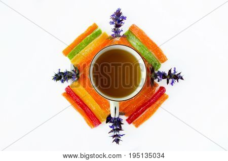 Cup Of Tea With Pineapple Candied Fruits And Blue Field Flowers On A White Background